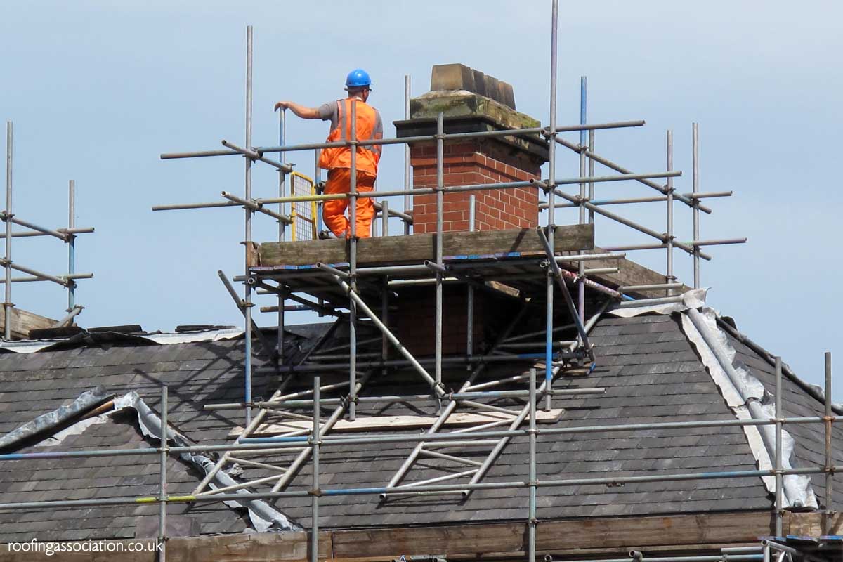 Chimney with scaffolding and a team removing it on a home in Norwich